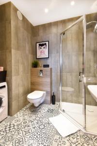 a bathroom with a shower and a toilet and a sink at W&K - White&Grey - Faktura VAT, Netflix, Parking w garażu, Blisko dworca i centrum in Koszalin