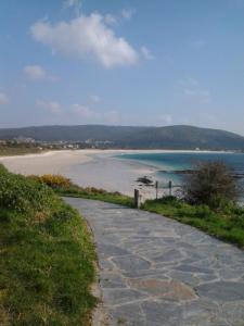 un camino de piedra que conduce a una playa junto al océano en Apartamento San Roque, en Finisterre