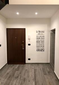 ein Zimmer mit einer Tür und einer Wand mit Worten drauf in der Unterkunft Corte Del Carmine in Bari