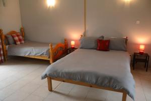 a bedroom with two beds and two candles on tables at Le Grehando in Le Guerno