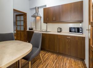 a kitchen with wooden cabinets and a table with chairs at Apartamenty Asia Basia in Kudowa-Zdrój