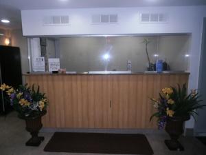 a reception desk with two vases of flowers at The Vue Express @ 39th Street in Brooklyn