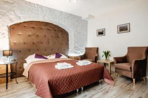 Un dormitorio con una cama grande y dos sillas. en Olejna 12, en Lublin