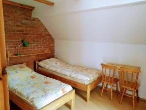 a room with two twin beds and two chairs at Pensjonacik Gafel in Ruciane-Nida