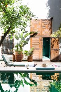 a swimming pool with a surfboard in front of a house at Riad Le Rihani in Marrakesh