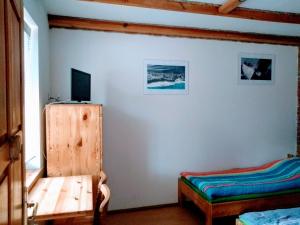 a room with a table and a tv on a wall at Pensjonacik Gafel in Ruciane-Nida