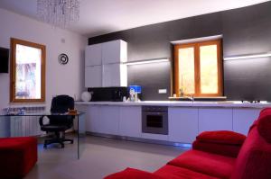 a kitchen with a red couch and a red chair at Sogni D'Oro in Agrigento
