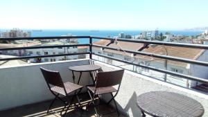 balcón con 2 sillas, mesa y vistas al océano en B&B Hostel CasaMoro, en Viña del Mar