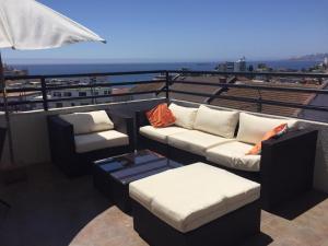 a balcony with couches and chairs on a roof at B&B Hostel CasaMoro in Viña del Mar