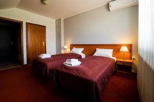 ein Hotelzimmer mit 2 Betten mit roter Bettwäsche in der Unterkunft Extrans in Olchowa