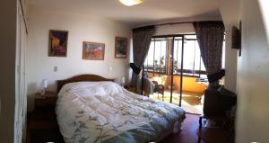 a bedroom with a bed and a door to a balcony at Beachfront Apartment Reñaca Chile in Viña del Mar