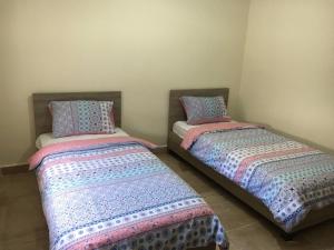 two beds sitting next to each other in a room at Oued Laou - Ground Floor in Oued Laou