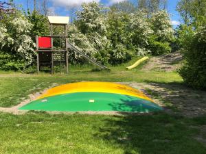 un objeto amarillo y verde en la hierba con un parque infantil en Vakantiehuisjes Robersum en Vierhuizen