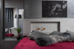 a bedroom with a red bed with two glasses of wine at Boutique Hotel Chevalier - Adults Only in Medulin