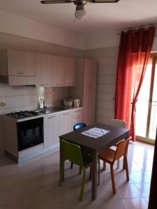 a kitchen with a table and chairs and a stove at Case vacanze LE ROSE in Campofelice di Roccella
