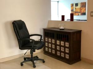 a black office chair sitting next to a cabinet at Family Friendly 3 Rooms Apartment in Mexico City