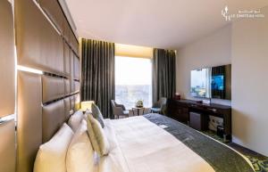 une chambre d'hôtel avec un lit, un bureau et une télévision dans l'établissement LeChateau Boutique Hotel, à Djeddah