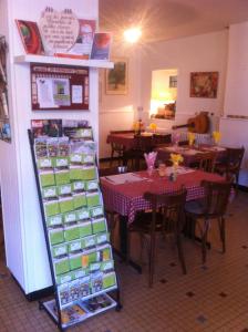 a restaurant with a table and tables with tables and chairs at AUBERGE LA ROMAINE in Maizières