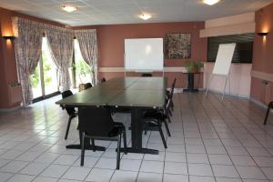 a conference room with a table and chairs at Hôtel Le Palous in Baraqueville