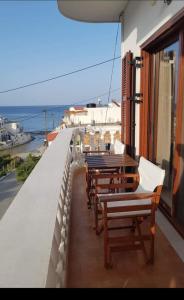 un balcón con mesas y sillas y el océano en Anesis en Diafani