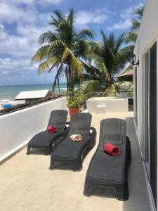 Duas cadeiras numa varanda com vista para o oceano em Skyline Suite em Playa del Carmen