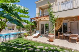 a villa with a swimming pool and a house at Cretamos Seaside Villas in Kissamos