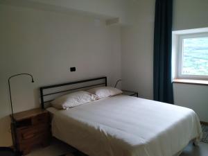 Schlafzimmer mit einem weißen Bett und einem Fenster in der Unterkunft B & W KRIŽ in Ajdovščina