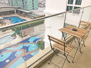 a table and chair on a balcony with a swimming pool at D'Esplanande Residence Homestay by WELCOME HOME in Johor Bahru