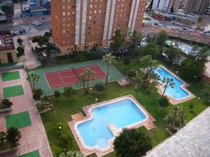 una vista aérea de una piscina y una pista de tenis en Gemelos XII - Fincas Arena, en Benidorm