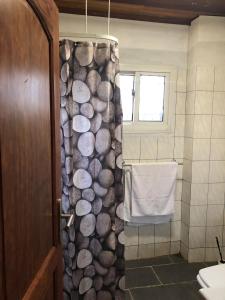 a bathroom with a shower with a wall of logs at VILLA MANGA in Yaoundé