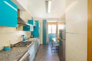 a large kitchen with blue cabinets and a counter top at Blue Ocean House in Lagos