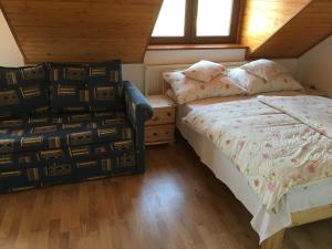 Un dormitorio con 2 camas y una silla. en Csók Apartmanház, en Balatonfüred