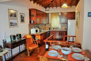 a kitchen with wooden cabinets and a table with plates on it at Melpomeni Villa in Mythimna