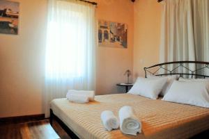 a bedroom with a large bed with towels on it at Melpomeni Villa in Mythimna