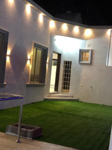 a house with a lawn with lights on it at شاليه الماسة in Taif