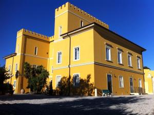ein gelbes Gebäude mit einem Turm darüber in der Unterkunft Villa Graziani in Vada