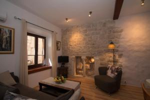 a living room with a stone wall with a fireplace at Apartments Sunny Town in Korčula
