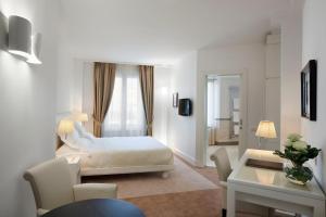 a hotel room with a bed and a desk and a room at Maison Milano | UNA Esperienze in Milan