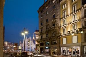 uma rua da cidade com edifícios e uma catedral ao fundo em Maison Milano | UNA Esperienze em Milão