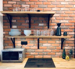 a microwave sitting on a shelf next to a brick wall at Lofty & Apartamenty Garnizon Gdańsk in Gdańsk