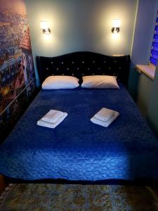 - une chambre avec un lit bleu et des serviettes dans l'établissement Little Paris Apartment, à Tchernivtsi