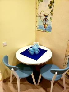 - une table avec deux chaises et une table avec des bols dans l'établissement Little Paris Apartment, à Tchernivtsi