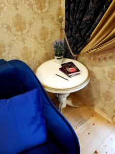 een tafel met een blauwe stoel en een boek erop bij Little Paris Apartment in Tsjernivsi