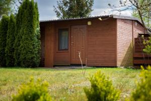 una piccola casa con una porta marrone in un cortile di U Mamy a Czarna Woda