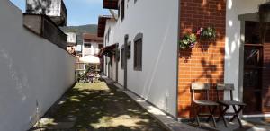 a narrow alley with two chairs and a building at Pousada Chalés Vereda do Sol in Ubatuba