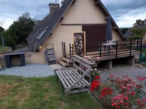 een huis met een hek en een bank en bloemen bij STUDIO ANSYLIA in Lantic