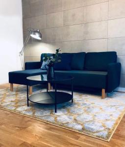sala de estar con sofá azul y mesa en Lofty & Apartamenty Garnizon Gdańsk en Gdansk