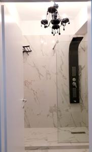 baño con suelo de mármol blanco y lámpara de araña en Studio Rendez-vous Baneasa, en Bucarest