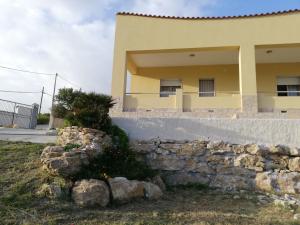 a house with a stone wall in front of it at Villa Fiorella in Sciacca