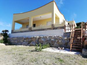 a house on the beach with a stone wall at Villa Fiorella in Sciacca
